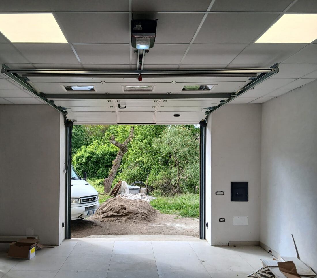 Interno garage con portone sezionale automatizzato LiftMaster in posizione aperta.