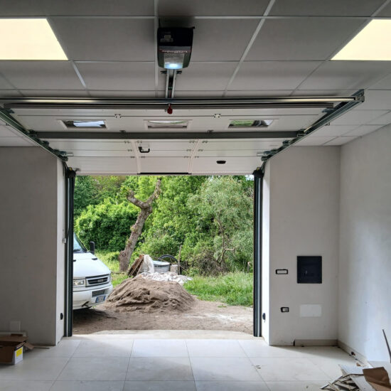 Interno garage con portone sezionale automatizzato LiftMaster in posizione aperta.